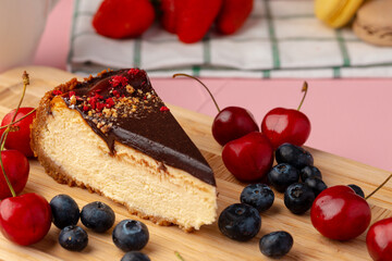 Piece of cheesecake with chocolate top and berries