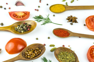 Spoons with spices and seasonings, fresh tomatoes, garlic and dill isolated on a white background.