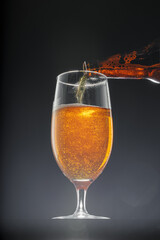 Beer pouring into glass on black background