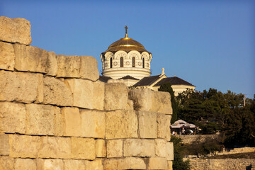 Fototapeta premium Tauric Chersonesus. Ruins of an ancient city on the beach at sunset. Ruins, antique columns. Vladimir cathedral. 