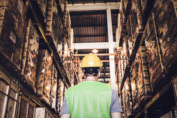 Blur background back view of warehouse men worker wearing hardhats and reflective jacket waking in...
