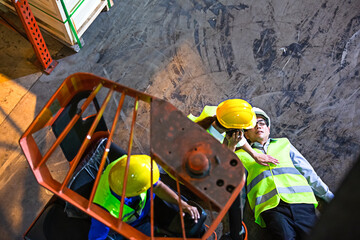 top view of warehouse worker lying down on floor after accident from forklift. woman try to help...