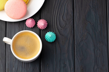Cup of coffee with colorful cookies close up