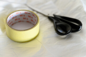 Scissors and adhesive masking tape on foil.
