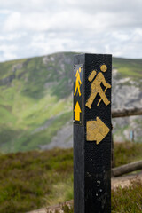 Close up of signpost of a walking man with a backpack with directional arrow point the correct...