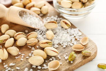 Pistachios with salt on white wooden table