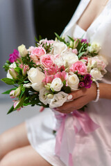 Wedding bouquet in hands of elegant bride on the wedding day. Copy space for text. Floral decorations and backgrounds for holiday cards and invitations.