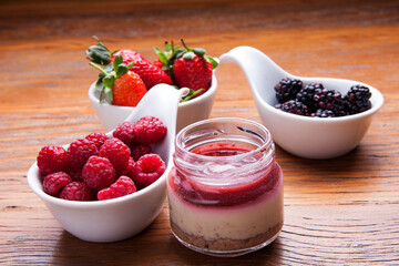 Nutrition concept - Healthy cheese cake in glass jars over wooden background. Healthy food, Diet, Detox, Clean Eating or Vegetarian concept. Delicious dessert option.