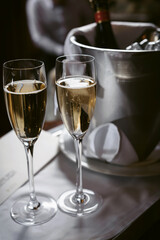 A bottle of champagne in an ice bucket and two glasses nearby. Luxury Hotel Room, Welcome Compliment for Guests