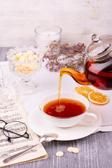 Pouring custard tea in a teapot with the addition of various additives and flavors
