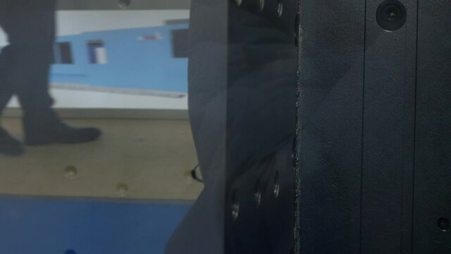 Production of plastic details in press molding machine. Blurred people on background