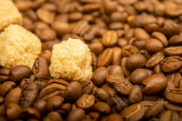 Chocolate, coffee beans, and chunks of brown cane sugar. Close up. Surface texture.