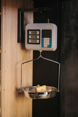 Slice of cheese weigh in cheese store. Piece of maasdam cheese