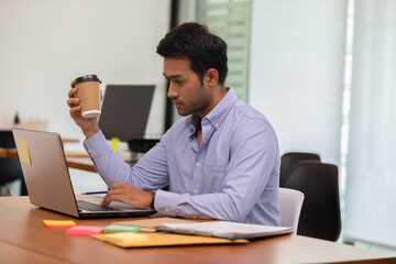 Portrait of Young business indian man working with laptop