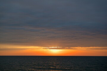 A narrow strip of clear sky over the horizon. The sky is covered with dense clouds.