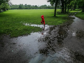 child playing in mud puddle at Meadows in Edinburgh