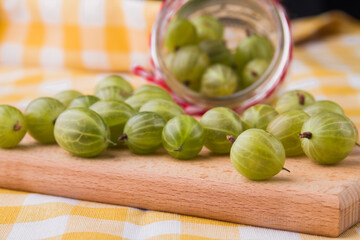 Many scattered cherry-cherry-plums on wooden board. Close-up.