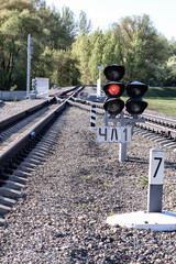 Red traffic light is lit on the empty train tracks