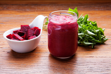 Nutrition concept - Healthy meals in glass jars over wooden background. Canned homemade beetroot in glass jar with fresh organic beetroots and rosemary plant.