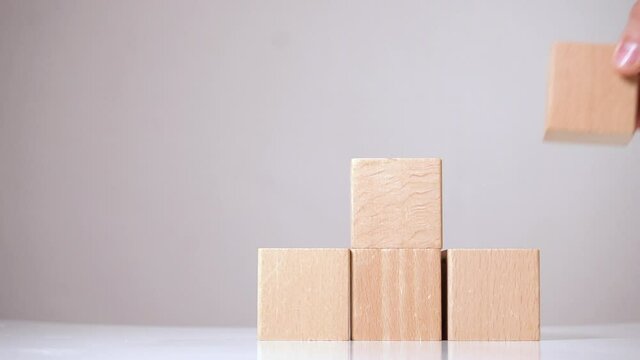 Man building some structure from wooden cubes