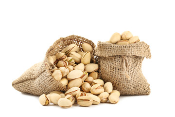 Tasty pistachios in sacks on white background