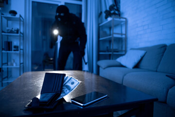 Robber breaking in an apartment with torch to steal something