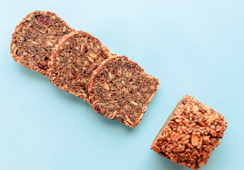 Sliced whole grain bread rye with seeds flax, sunflower, pumpkin and sesame.Healthy food, eco-friendly natural products. Fresh bread on a pink background.