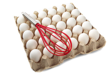 a red hand whisk resting on a carton of 30 white eggs isolated on white