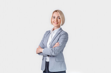 Beautiful happy businesswoman with crossed arms on grey background