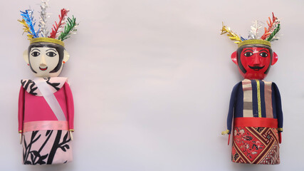 Miniature ondel ondel doll. To mark it, the male ondel-ondel has a red face, the female ondel-ondel has a white face. This doll comes from the Betawi tribal culture, Indonesia. Copy space for text.
