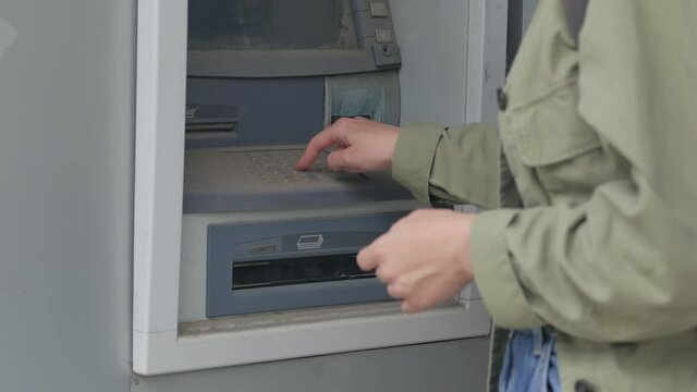 The woman unsuccessfully enters the pin code into the damaged ATM.
