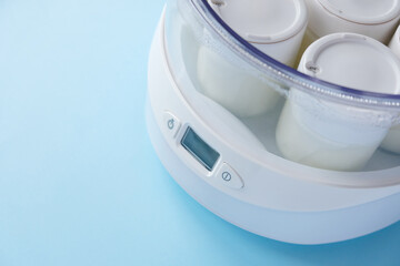 Fermented yogurt in yogurt machine on blue background