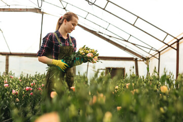 Beautiful  gardener woman holding bouquet of flowers and it smells. 