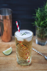 fresh summer drink with paper striped straw on the wooden table, ice tea