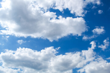 Naklejka na ściany i meble Thick clouds against the azure sky, bright sunny day.