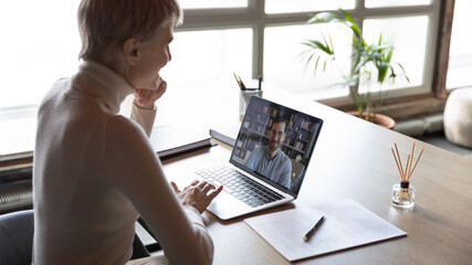 View over shoulder of HR manager looking at laptop screen listen applicant during distant online job interview. Hiring, remote negotiations, informal chat with friend at workplace, video event concept
