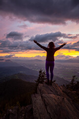 Fototapeta na wymiar Adventurous Girl on top of a Rocky Mountain overlooking the beautiful Canadian Nature Landscape during a dramatic Sunset. Taken in Chilliwack, East of Vancouver, British Columbia, Canada.