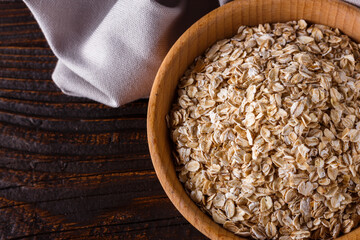raw oatmeal on a wooden rustic background