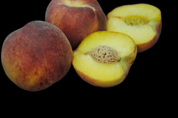 peaches on a black background, Fruits of organic peaches whole and halves