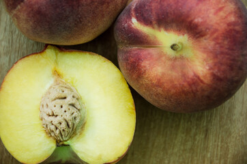 fresh peaches on a wooden background, Fruits of organic peaches whole and halves