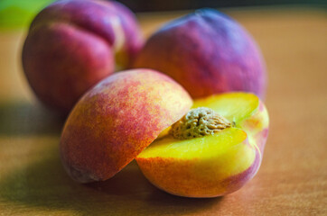 fresh peaches on a wooden background, Fruits of organic peaches whole and halves