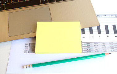 Minimal work space. A blank notebook with a pen lies on a laptop keyboard