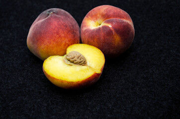 peaches on a black background, Fruits of organic peaches whole and halves