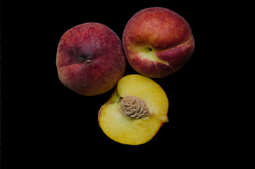 peaches on a black background, Fruits of organic peaches whole and halves