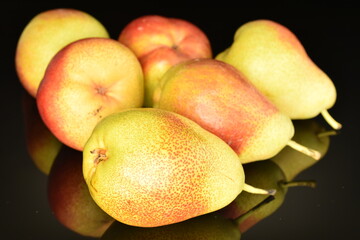 Organic juicy pears, close-up, on a black background.