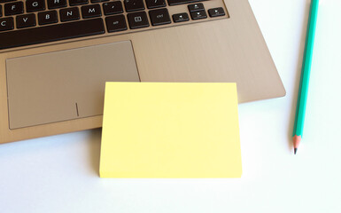 Minimal work space. A blank notebook with a pen lies on a laptop keyboard