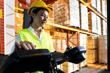 Asian warehouse worker with forklift in warehouse