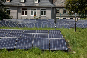 Wiese mit Feld von Solarzellen zur Stromerzeugung mit alternativen Energien