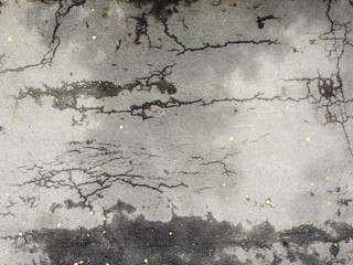 Cracks on the asphalt road surface, texture of the damaged road surface.