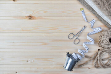 Naklejka premium Sewing supplies on a wooden background. Flat lay